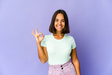 Young mixed race woman cheerful and confident showing ok gesture.