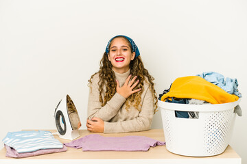 Wall Mural - Young caucasian woman ironing clothes isolated laughs out loudly keeping hand on chest.