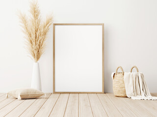 Poster - Vertical frame mockup standing on wooden floor in living room interior with dried pampas grass, woven basket, blanket and pillow with tassels on white wall background. 3d rendering, 3d illustration