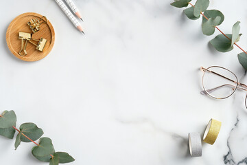 Wall Mural - Flat lay home office desk table. Feminine workspace with glasses, office supplies, greenery on marble background. Elegant freelancer workplace