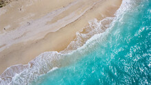 美しいアクアブルーの海と砂浜に白波が立つドローン俯瞰写真