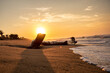 © Alejandro - Great sunrise at the beach with the sun above a wood log