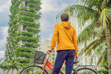 man looks at Eco architecture. Green cafe with hydroponic plants on the facade. Ecology and green living in city, urban environment concept. Modern building covered green plant