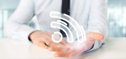 Poster - businessman holding a wifi icon with data all around