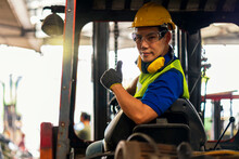 Engineer Or Technician Concept. A Male Employee Driving A Forklift And Showing Thumb Up In Factory.