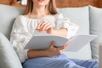 Canvas Print - Beautiful woman reading blank magazine in living room