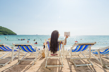 A girl enjoys reading book on the beach