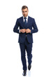 © Viorel Sima - confident young model walking and unbuttoning navy blue suit