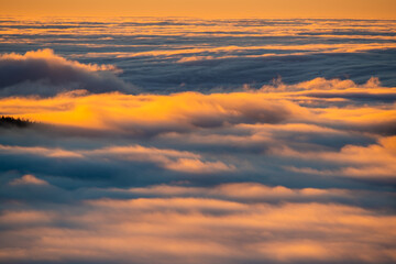 Wall Mural - beautiful cloud formations rolling over the mountain valley, lit by the light of the rising sun