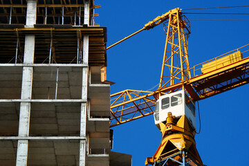 Wall Mural - Construction site.  Self-erection crane against blue sky. Industrial background.