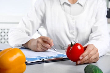 Wall Mural - scientist with laboratory test form and fresh tomato at table indoors, closeup. poison detection