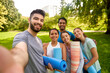 © Syda Productions - fitness, sport and healthy lifestyle concept - group of happy people with yoga mats taking selfie at park