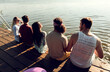 © Zoran Zeremski - Group of friends sitting on the edge of a pier having fun and enjoying a summer day at the lake.
