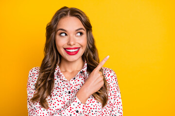 Portrait of adorable person look direct finger empty space beaming smile isolated on yellow color background