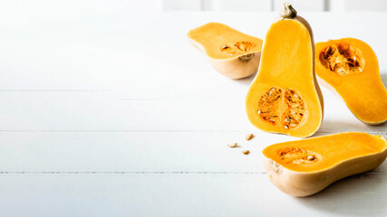 Butternut squash halves on white wooden table