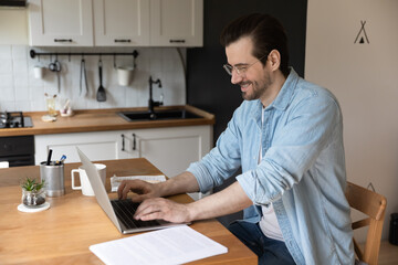 Wall Mural - distance training. confident young man trainee sitting by laptop at home office at kitchen having su