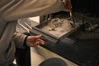 Silhouette d'un homme qui nettoie les cendres du bois de chauffage tombées dans un tiroir du foyer de la cheminée