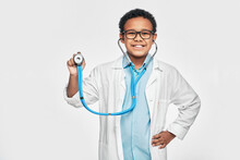 African American Boy Playing In Doctor Profession Using A Stethoscope. Child's Hobby And Future Medical Occupation. White Background