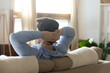 © fizkes - Close up rear view calm man resting on couch, leaning back with hands behind head, meditating or sleeping, enjoying leisure time, dreamy male planning day, dreaming about good future, opportunities