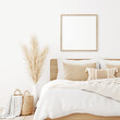Square frame mockup in boho bedroom interior with wooden bed, beige blanket, pillow with tassels, dried pampas grass and basket on white wall background. 3d rendering, 3d illustration