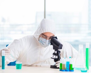 Young chemist student working in lab on chemicals