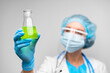 © fotofabrika - Woman scientist holding laboratory flask with chemical liquid, gray background
