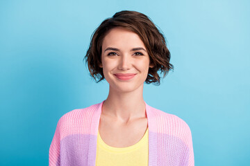 close-up portrait of attractive cheerful brown-haired girl wearing knitwear isolated over bright blu