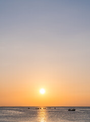Wall Mural - sunset sky vertical over sea in the evening and fishing boat with colorful orange sunlight and sundo