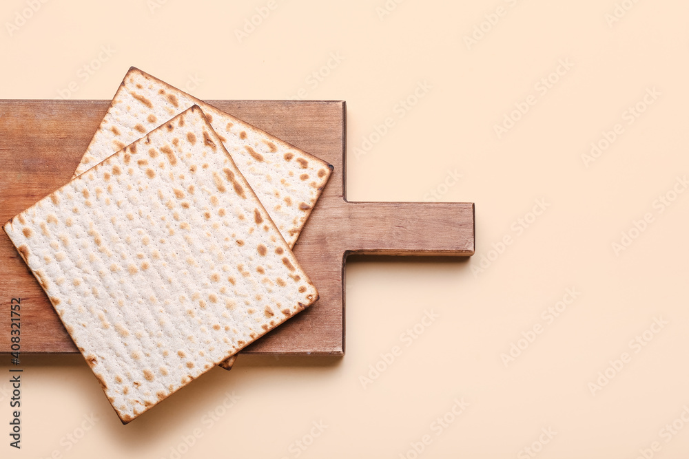 Board with Jewish flatbread matza for Passover on color background