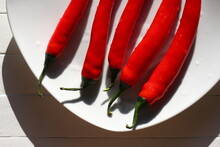 Washed, Cleaned Chili Bell Peppers On A White Plate In The Sunlight On A White Wooden Table