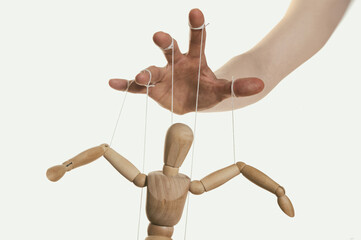 Wall Mural - Concept of control. Marionette in human hand. Close-up.