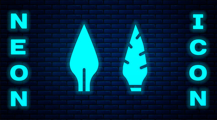 Sticker - Glowing neon Stone age arrow head icon isolated on brick wall background. Medieval weapon. Vector.