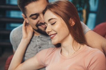 Wall Mural - Adorable ginger woman with freckles is embracing her lover while dating on valentines day