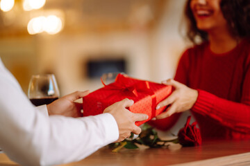 Wall Mural - Exchange of gifts.  Young couple in love offering gift to each other for valentine day or birthday. Romantic day. Winter holidays.