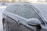Fototapeta Tulipany - Samochód zasypany śniegiem na parkingu zimową porą, auto przykryte białym puchem śnieżnym