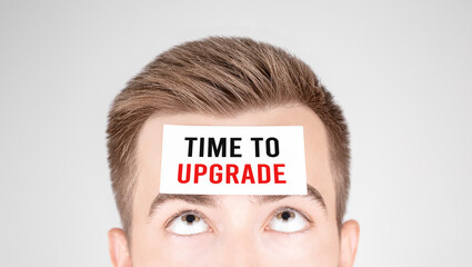 Poster - Man looking at paper with word Time to upgrade pasted on his forehead