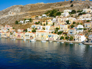 houses, buildings and castle with yachts and boats in the  port town of Simi a Greek island in the Aegean