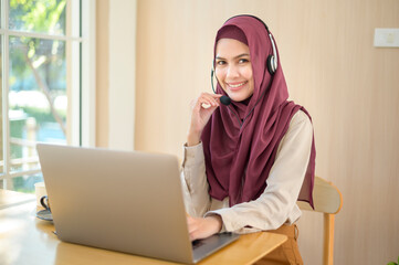 Muslim operator woman in headset using computer answering customer call in office, Customer service concept