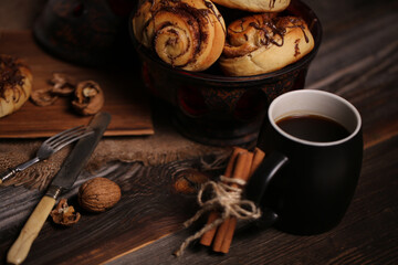 Canvas Print - Closeup shot of a black tea mug near a vase full of tasty biscuits