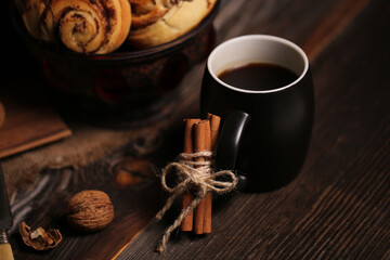 Canvas Print - Closeup shot of a black tea mug near a vase full of tasty biscuits