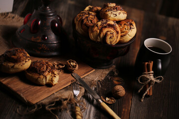 Canvas Print - Closeup shot of a black tea mug near tasty biscuits