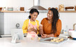 © Agnes Lopez - African American mother and daughter baking cookies in the kitchen