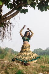 Portrait of beautiful Indian girl in selective focus. Young hindu woman in traditional Indian costume lehenga choli or sari or saree