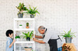 © artitwpd - Asian retirement grandfather and his grandson with smiles, spending quality time together by enjoy taking care of plants in an indoor garden. Family bonding between old and young.