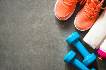 Sneakers, dumbbell, towel and bottle of water. Trayning, workout and fitness concept. Flat lay image with copy space.