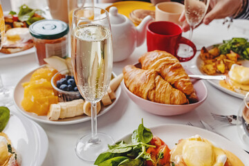 Glass of champagne close-up on the table with different breakfast and brunch dishes