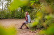 © Bernd Friedel/Westend61 - Thoughtful smiling woman looking away while sitting on bench in park