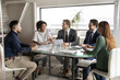 © fizkes - Interested diverse colleagues listening to leader, discussing statistics, sitting at table in modern boardroom, mentor coach explaining strategy, giving instructions to workers at briefing