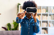 © Giorgio Fochesato/Westend61 - Woman wearing virtual reality headset stretching hand while standing at home
