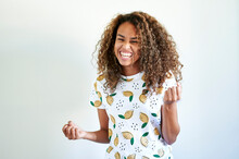 Happy Afro Young Woman Triumph Gesturing Against White Wall